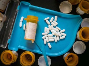 Unsorted prescription pills sit in a pharmacist's counting tray before they are bottled.