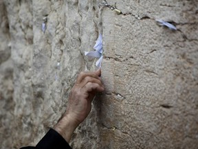 A note is pressed into the Western Wall in Jerusalem during Passover in 2011.