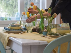 Small, household gatherings can still be festive. A spring-themed table set for Easter dinner features nests filled with eggs, miniature soda bottles with tulips and ranunculus flowers, pastel-coloured table linens and patterned dinnerware, Monday, March 11, 2013.