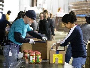 Bruce Dawe, left and Leila Ben Ammar volunteer and help pack food boxes at Moisson Montreal as the city deals with the coronavirus crisis in Montreal, on Thursday, March 26, 2020. With sacrifice and solidarity, our generation can build a better future, Christopher Holcroft writes.