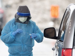Health care workers carry out drive-through tests for COVID-19 at an installation at the Cavendish Mall as the city deals with the coronavirus pandemic in Montreal, on Monday, March 30, 2020.