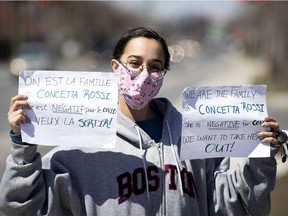 Raminder Bindra holds up signs asking for the release of her grandmother, Concetta Rossi, 93 yrs, from Notre-Dame-de-la-Victoire, a private CHSLD in the St. Hubert district as the city deals the with coronavirus pandemic in Montreal, on Monday, April 20, 2020.