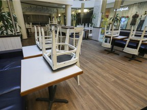 Chairs stacked on tables at a restaurant closed due to the coronavirus  crisis, in Les Cours Mont-Royal.