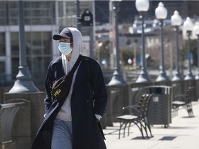 A man wears a mask while walking in Montreal’s Old Port on April 23, 2020, during the COVID-19 crisis.