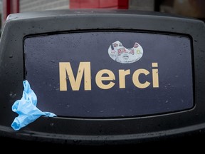 A single-use surgical glove sticks out of a trash can at a fast food restaurant as the city deals with the coronavirus pandemic in Montreal, on Monday, March 30, 2020.