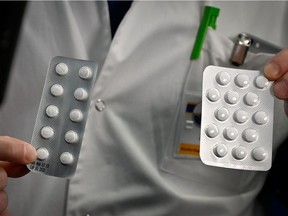 (FILES) In this file photo taken on February 26, 2020, medical staff shows o at the IHU Mediterranee Infection Institute in Marseille, packets of a Nivaquine, tablets containing chloroquine and Plaqueril, tablets containing hydroxychloroquine, drugs that has shown signs of effectiveness against coronavirus. - Hydroxychloroquine, an antimalarial drug dubbed a "gift from God" by US President Donald Trump for its potential ability to fight the new coronavirus, was found to be no more effective than standard treatment in a small Chinese study. The paper, which was published in the Journal of Zhejiang University on March 6, 2020, looked at 30 COVID-19 patients, half of whom received the medicine. (Photo by GERARD JULIEN / AFP)