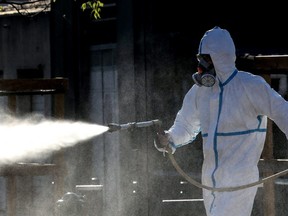 A technician sprays disinfectant along the streets of the French Riviera city of Cannes, southern France, on Friday, April 10, 2020.