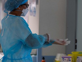 A medical staff puts protective gloves on at an especially created Post Resuscitation Unit (Unité Post Réanimation Respiratoire) for COVID-19 infected patients on April 17, 2020 at the Emile Muller hospital in Mulhouse, eastern France, as France is on the 32nd day of a strict lockdown aimed at curbing the spread of the COVID-19 pandemic caused by the novel coronavirus. (Photo by PATRICK HERTZOG / AFP) (Photo by PATRICK HERTZOG/AFP via Getty Images)