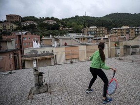 Vittoria Oliveri (front) plays tennis with Carola in background on rooftops of their house in Finale Ligure, Liguria Region, northwestern Italy on April 19, 2020, during the country's lockdown aimed at stopping the spread of the COVID-19 (new coronavirus) pandemic.