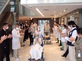 Health workers applaud as a recovered 97-year-old lady is discharged from a hospital in Sao Paulo, Brazil, on Sunday, April 12, 2020, in this screen grab taken from social media video.