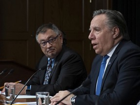 Quebec Premier François Legault, with public health official, Horacio Arruda, responds to reporters during a news conference on the COVID-19 pandemic.
