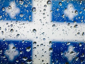 The Quebec flag seen through water drops on a window.