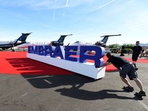 Workers set up at the Embraer booth prior to the opening of the National Business Aviation Association (NBAA) exhibition in Las Vegas, Nevada, U.S. October 21, 2019. REUTERS/David Becker/File Photo