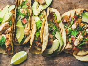 Tacos with grilled chicken, avocado, fresh salsa sauce and limes