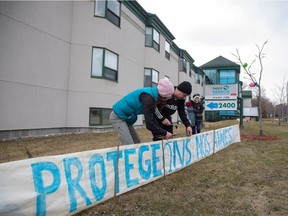 A family places a sign reading "Protect our seniors" outside Residence Herron, a senior's long-term care facility, following a number of deaths since the coronavirus disease (COVID-19) outbreak, in the suburb of Dorval in Montreal Quebec, Canada April 12, 2020.  REUTERS/Christinne Muschi
