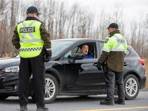 Sûreté du Québec police officers set up a checkpoint for drivers approaching the province from neighbouring Ontario.