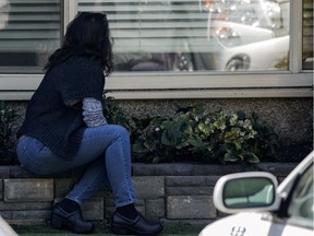 A woman talks through a window to her mother inside a long-term care centre in Kirkland, Wash., on March 18, 2020.