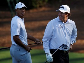 FILE PHOTO: U.S. golfers Tiger Woods (L) and Phil Mickelson walk to the 11th tee during the second day of practice for the 2018 Masters golf tournament at Augusta National Golf Club in Augusta, Georgia, U.S. April 3, 2018.