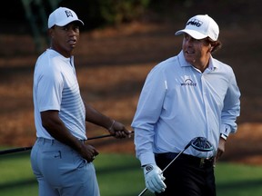 U.S. golfers Tiger Woods, left, and Phil Mickelson walk to the 11th tee during the second day of practice for the 2018 Masters golf tournament at Augusta National Golf Club in Augusta, Georgia, U.S. April 3, 2018.