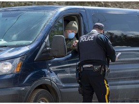 A soldier talks with an RCMP officer at a checkpoint in Portapique, N.S. on Thursday, April 23, 2020. The military has provided personnel, modular tents, lights, tables, chairs and generators to a number of locations in the province. RCMP say at least 22 people are dead after a man who at one point wore a police uniform and drove a mock-up cruiser, went on a murder rampage in Portapique and several other Nova Scotia communities.