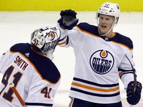 Edmonton Oilers goaltender Mike Smith (41) and center Colby Cave (12) celebrate after defeating the Pittsburgh Penguins at PPG PAINTS Arena. The Oilers won 2-1 in overtime.