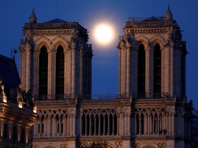 The "pink supermoon" rises between the two towers of Notre Dame Cathedral in Paris on April 7 ahead of Easter celebrations to be held under lockdown.