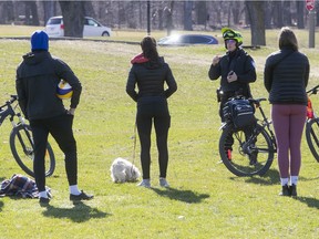 Montreal police officer issues a verbal warning to a group of friends at Jeanne Mance park Monday April 20, 2020.