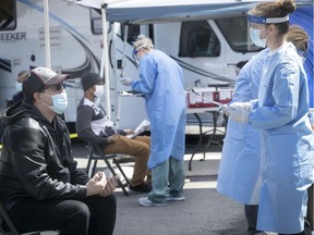Health-care workers interview St-Michel residents who visited a mobile COVID-19 testing clinic May 3, 2020.