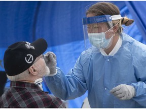 A healthcare worker administers a COVID-19 test to a resident of St-Michel in Montreal on May 3, 2020.