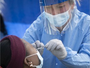 A healthcare worker administers COVID-19 test to a resident of St Michel on Sunday May 3, 2020 during mobile testing clinic. (Pierre Obendrauf / MONTREAL GAZETTE) ORG XMIT: 64337 - 4564