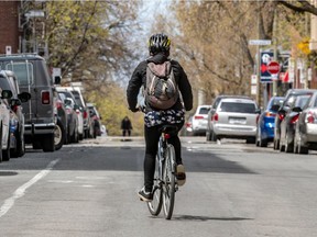 A cyclist rides alone down Montreal street on May 6, 2020, during COVID-19 pandemic.