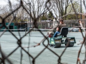 A worker gets courts at the Hampstead Tennis Club at Hampstead Park prepared on May 7, 2020 for when the club can open.