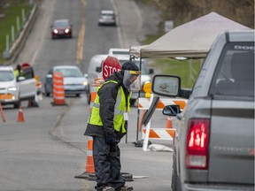 Anthony Fournier-Phillips mans a traffic control station on the Route 344 entrance to the Kanesatake Mohawk territory northwest of  Montreal Friday May 8, 2020.