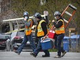 Construction workers wear masks as they leave a job site in Nuns' Island May 11, 2020.