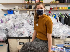 Camille Goyette-Gingras, co-founder of Coop Couturiers Pop, poses in front of bags containing 30,000 masks in Montreal on May 13, 2020.