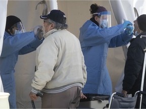 Health-care workers administer COVID-19 tests at an outdoor clinic at the CLSC Montréal-Nord on Wednesday May 13, 2020.