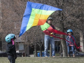Luis Juarez puts kite in the air for his son Diego, right, and daughter Mari-Rosa at Pere Marquette Park on Thursday May 14, 2020. (Pierre Obendrauf / MONTREAL GAZETTE)