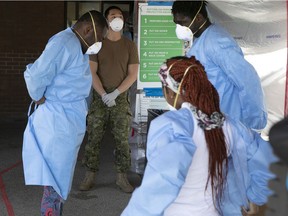 Canadian Armed Forces personnel oversees the donning of personal protective equipment by personnel of CHSLD Vigi Mont-Royal on May 14, 2020.