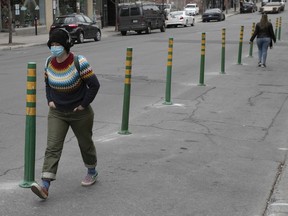 Pedestrians walk along new designated walkway on St-Laurent Blvd. on May 15, 2020. The city plans to reduce vehicle traffic on city streets to make them more pedestrian/cyclist friendly.