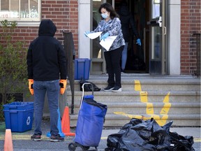 Parents collect their children’s belonging from Grand Heron School in Montreal during the COVID-19 pandemic on Wednesday, May 13, 2020.
