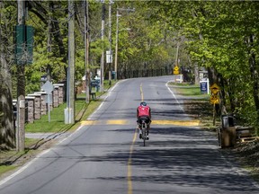 A cyclist rides down the middle of Senneville Rd. in Senneville, west of Montreal, on May 20, 2020.