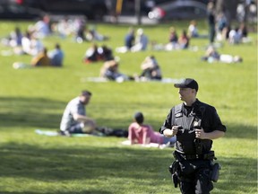 Police officers keep an eye on a busy Jeanne-Mance Park on Monday, May 18, 2020. Regardless of the potentially awkward waltz of socializing while social distancing, Allison Hanes writes, the loosening of some protective measures as of Friday will lift downtrodden spirits.