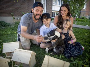 Daniel Landrigan gives a treat to the family dog Cash with son Theo, daughter Cassie and his wife, Michelle Ford, at their home in Lachine.