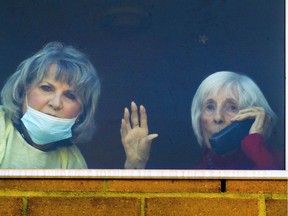 Brenda Roland waves from her fourth-floor room at CHSLD St-Lambert-sur-le-Golf, with daughter Shirley Delage at her side.