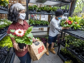 Kay Youm, right, helps Lenonara Mondaca pick out flowers at the Fleuressence flower shop on Monkland Ave. in the Notre-Dame-de-Grâce district of Montreal on May 25, 2020. It was the first day retail stores were allowed to open since the coronavirus lockdown.