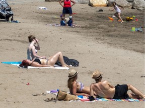 People maintain social distancing at the Verdun Beach on a hot, humid day in Montreal on May 26, 2020.