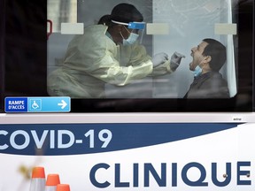 A health-care worker administers a COVID-19 test swab at a mobile  testing site in  Montreal on May 9, 2020.
