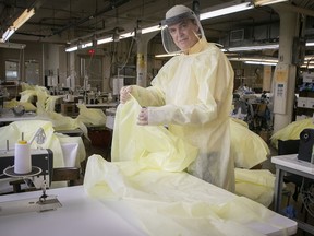 Alan Abramowicz, president of Samuelsohn, wears protective equipment as he looks at disposable gowns coming off the factory floor.
