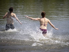 A couple splash in the water together to cool off at Verdun beach in Montreal on May 26, 2020.