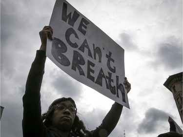 Protester holds up sign during an anti-racist and anti-police brutality demonstration on Sunday, May 31, 2020, in Montreal.